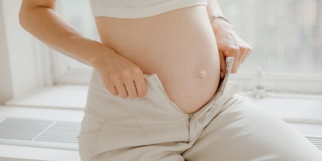 pregnant woman fitting pants