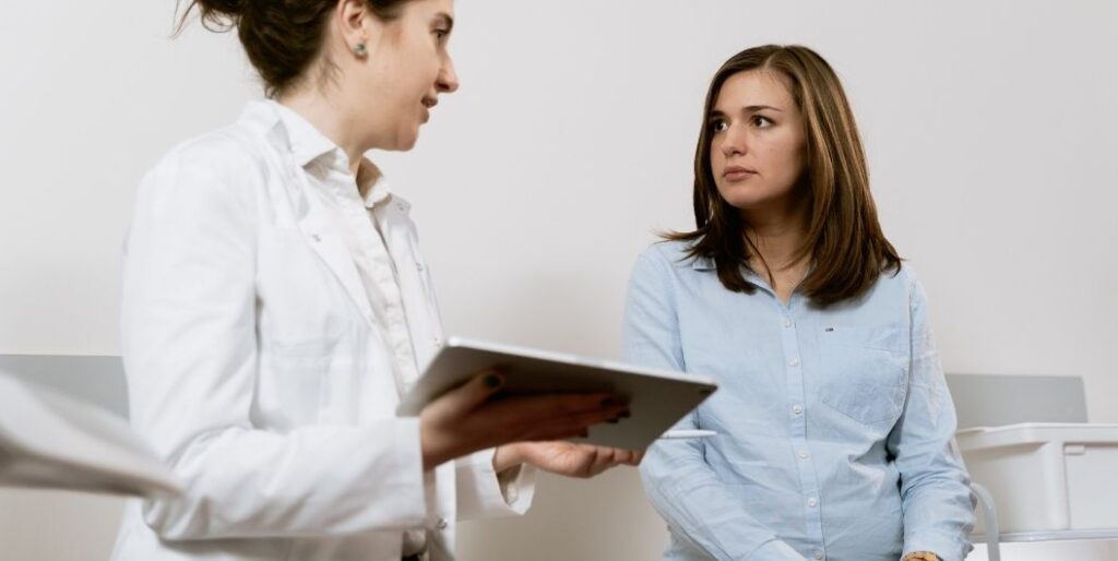 pregnant woman talking to a doctor