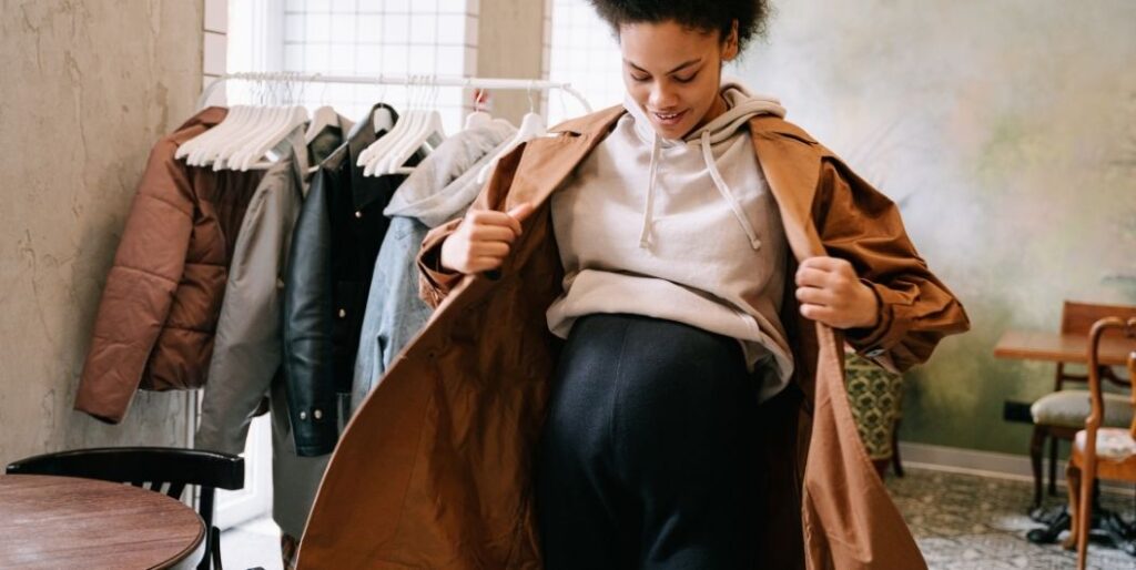 pregnant woman fitting a coat