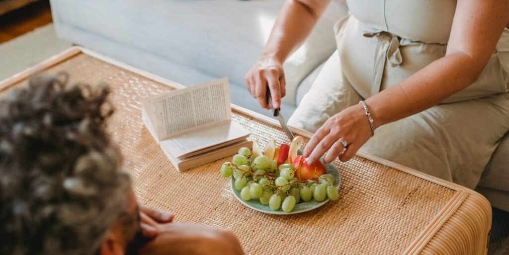 pregnant woman slicing fruits