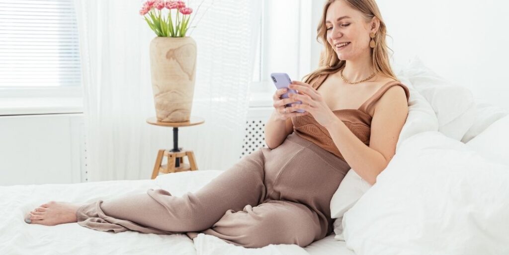 pregnant woman sitting on her bed